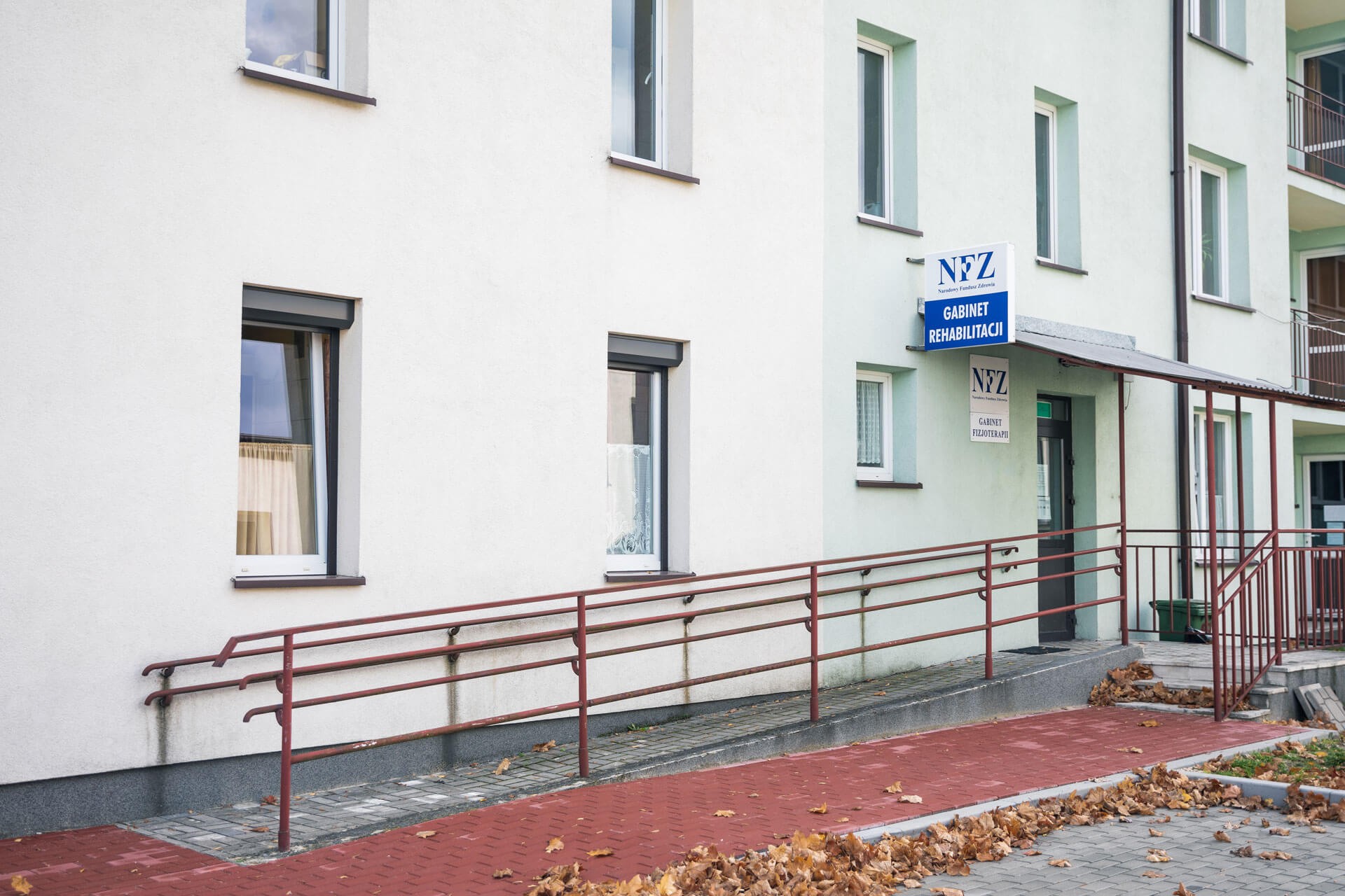 Wejście do budynku z widocznymi schodami oraz podjazdem dla wózków